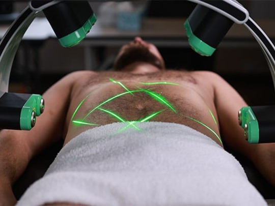 Emeralds gröna laserlinjer över magen under en behandling